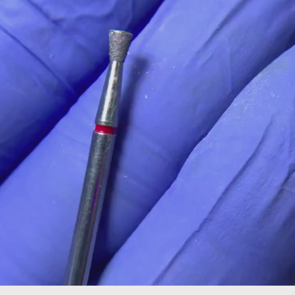 Primer plano de una broca de manicura con forma de cono inventido banda roja.